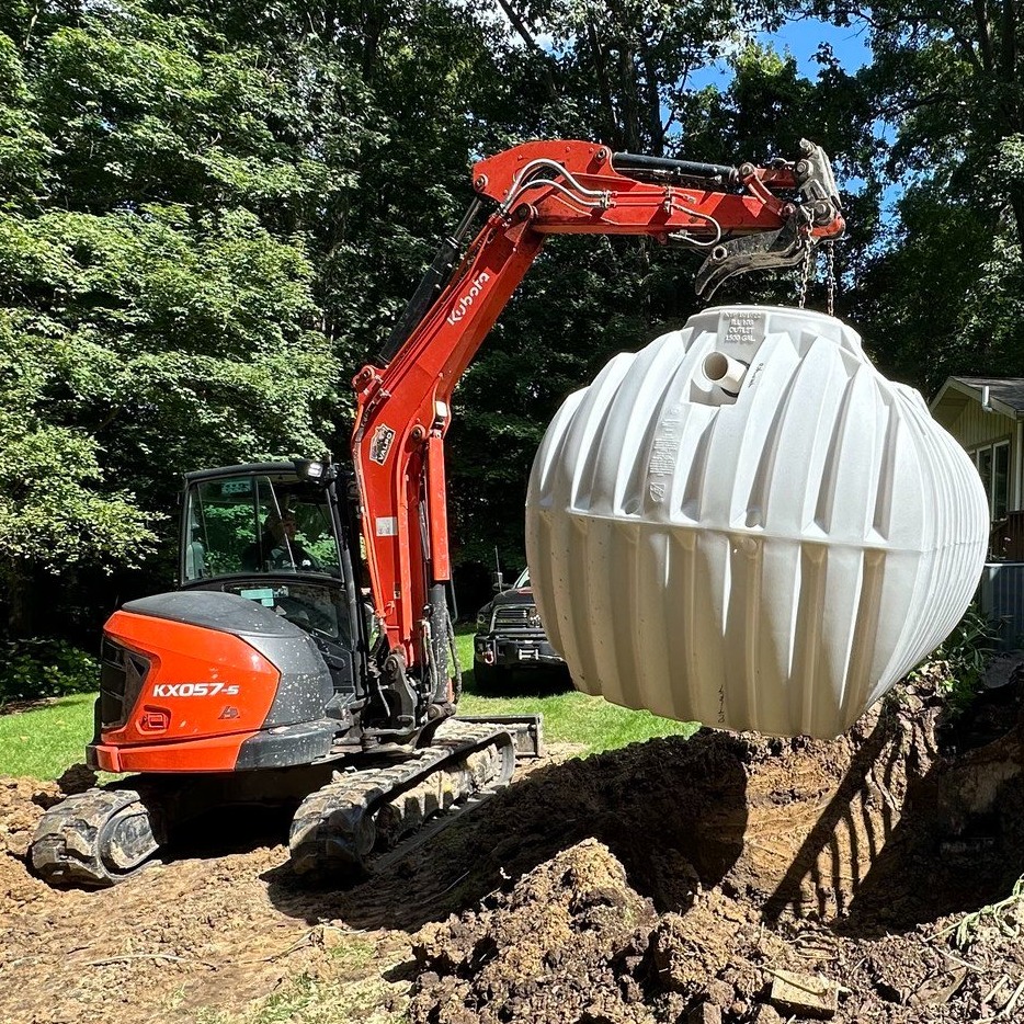 Excavator lifting septic tank